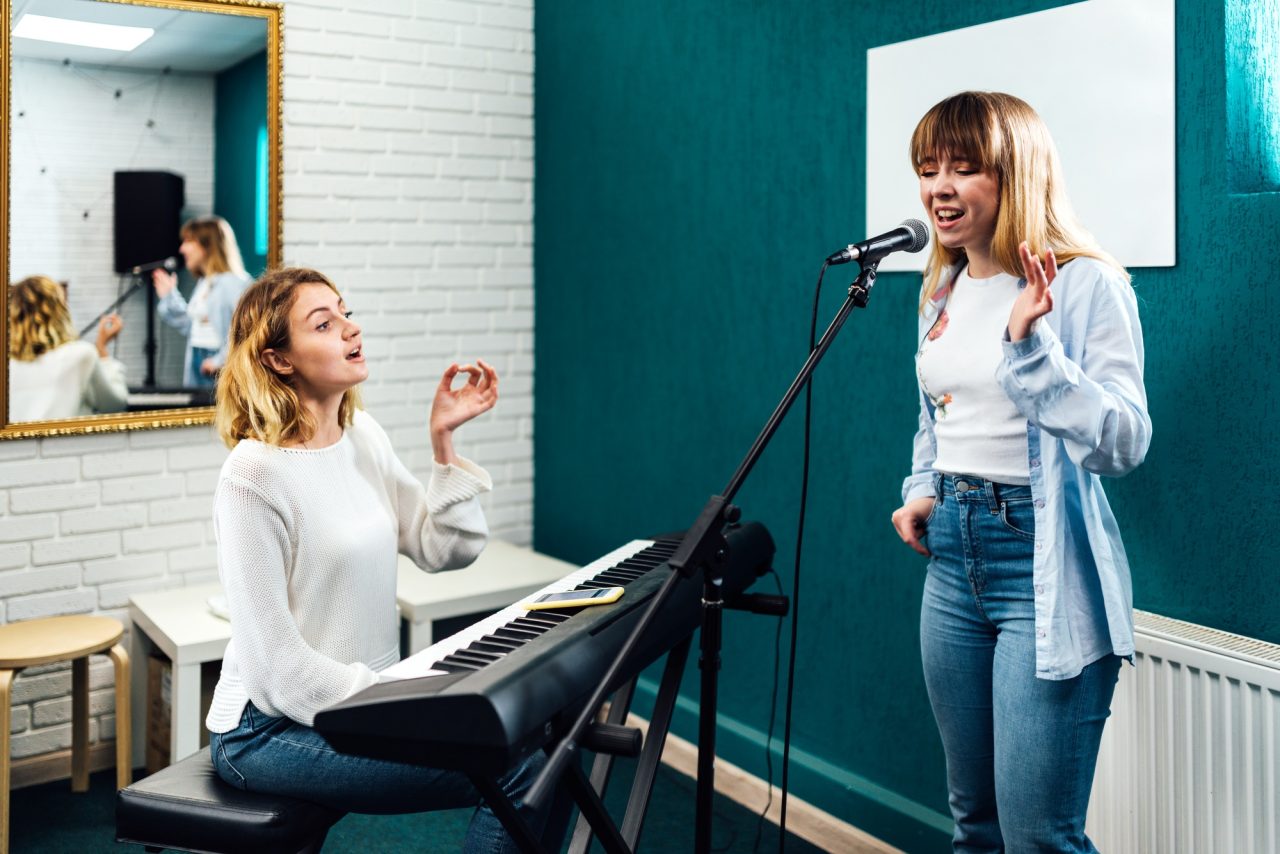 Vocal coach training her student's voice on a lesson