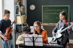 Young Music Teacher Working With School Band